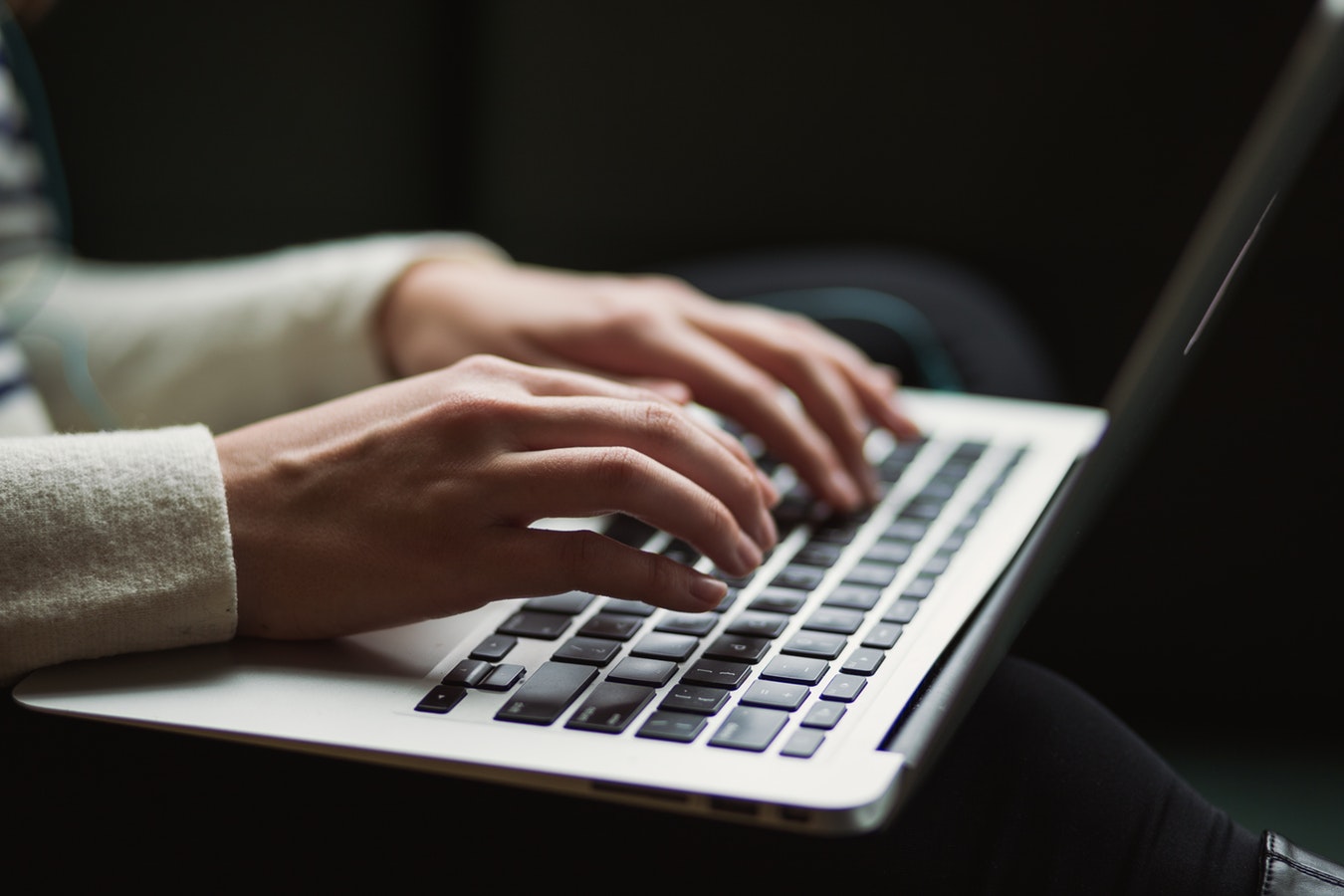 Person's hands typing on laptop computer